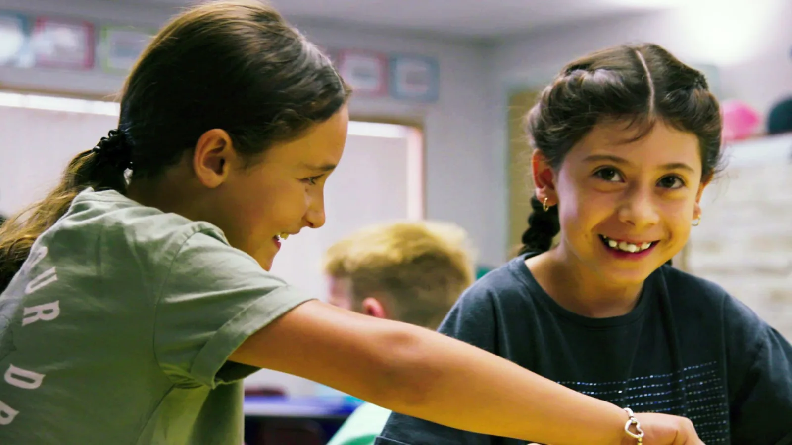 A small group of students works a performance task together at a classroom screen
